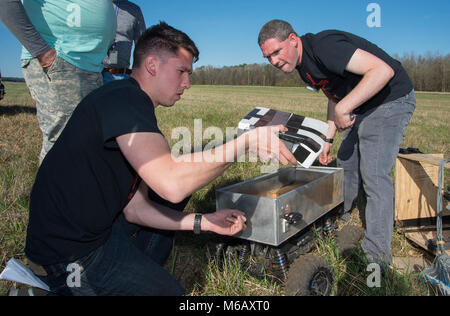 Fabian Pacheco und Patrick Cunningham, beide mit Team Kirtland abrufen, einen kleinen, autonomen Fahrzeug, 28.02.2018, per Fallschirm als Teil Ihres Teams Air Force Research Laboratory Commander's Challenge Demonstration 2017 fallengelassen worden waren. Der Plan wurde für das Fahrzeug auf seine eigene zu einem ausgewiesenen rendezvous Website zu fahren, aber es war in der Dropdown-liste beschädigt. (U.S. Air Force Stockfoto