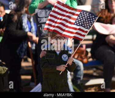 Ein Junge Wellen eine amerikanische Flagge auf der Flightline in Dyess Air Force Base, Texas, Jan. 19, 2018. Viele Familienmitglieder waren mit ihren Lieben wiedervereint nach mehr als 100 Flieger zum 317. Airlift Wing zugewiesen vom Horn von Afrika nach einer viermonatigen Einsatz zurück. (U.S. Air Force Stockfoto