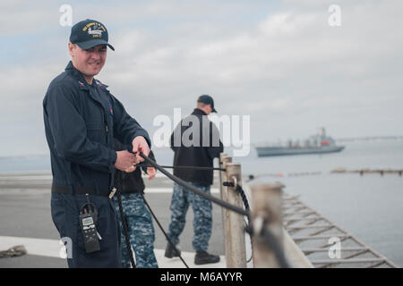 NORFOLK, Va (Feb. 22, 2018) der Luftfahrt Bootsmann Mate (Handling) 1. Klasse Jeremy Luther zieht einen Safety Line durch eine Haltestange an Bord der Flugzeugträger USS George H.W. Bush (CVN 77). Das Schiff ist im Hafen in Norfolk, Virginia, die Durchführung von routinemäßigen Wartung in Vorbereitung für den Vorstand der Überprüfung und Besichtigung (INSURV). (U.S. Marine Stockfoto