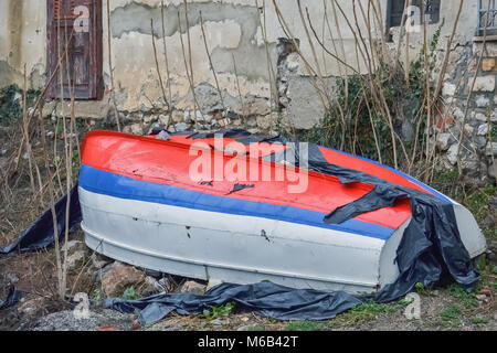 Kleines Fischerboot im Hof eines Hauses auf den Kopf gestellt Stockfoto