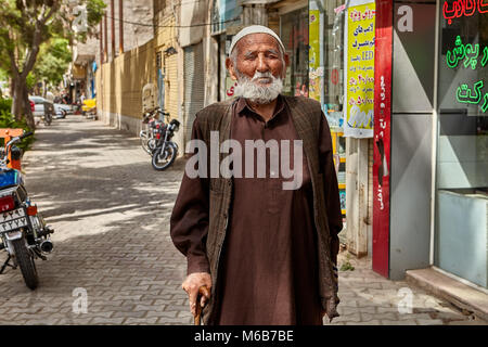 Kashan, Iran - 27. April 2017: Ein Mann von fortgeschrittenen Jahren ist zu Fuß auf dem Gehweg der Straße der Stadt. Stockfoto