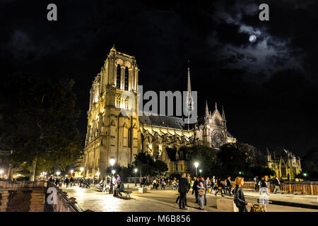 Spät in der Nacht Blick auf Kathedrale Notre Dame von der Pont au genommen Double Bridge auf der Ile de la Cite bei Vollmond mit Massen dabei auf Erschliessung Nacht Stockfoto