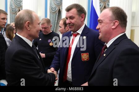 Der russische Präsident Wladimir Putin begrüßt Goldmedaillenträger Cheftrainer der Russischen Olympischen Eishockey Team Oleg Znarok, Mitte, bei einem Empfang im Kreml Februar 28, 2018 in Moskau, Russland. Stockfoto