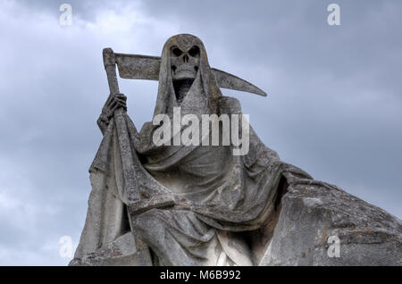 Der Tod personifiziert als Skelett mit Umhang und Sense dieses Bild der verwitterte Skulptur auf dem Friedhof getroffen wurde. Stockfoto