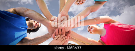 Das zusammengesetzte Bild im Low Angle View von Freunden huddling Stockfoto