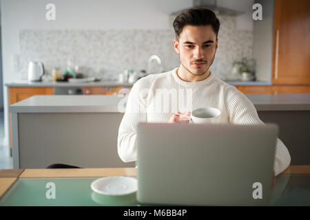 Portrait des jungen Mannes zu Hause Arbeiten am Notebook Stockfoto