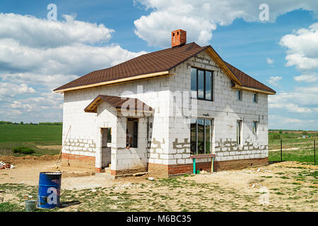 Bau des neuen Cottage aus weissem Stein auf Hintergrund blauer Himmel Stockfoto