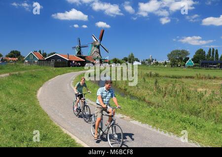 ZAANSE SCHANS, Niederlande - 9. JULI 2017: Radfahrer besuchen Windmühlen von Zaanse Schans. Niederlande hat 35.000 km Radwege physisch voneinander getrennten Stockfoto