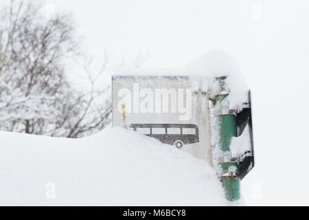 Bus Stop-Schild im Schnee bedeckt - der öffentliche Verkehr im Winter Konzept - Schottland, Großbritannien Stockfoto