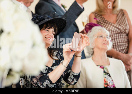 Mutter des Bräutigams ist Fotografieren der Zeremonie ihrer Söhne Hochzeit. Stockfoto