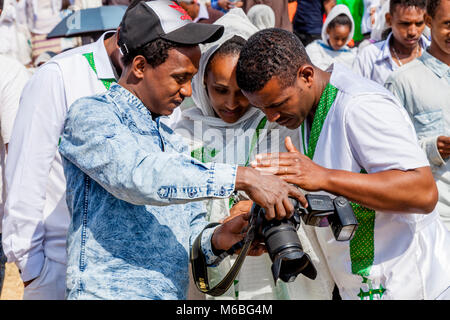 Eine äthiopische Fotograf zeigt die Leute Fotos von sich während Timkat (Epiphanie) Feiern, Jan Meda-Sportplatz, Addis Abeba, Äthiopien Stockfoto