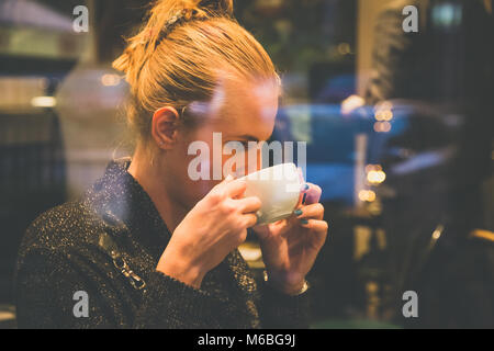 Nahaufnahme, Porträt der jungen schönen Frau trinken Latte Macchiato im Café Stockfoto