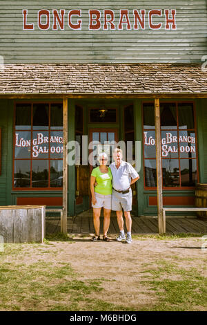 Paar außerhalb Long Branch Saloon in Dodge City, Kansas. Gebäude ist Teil des Boot Hill Museum. Stockfoto