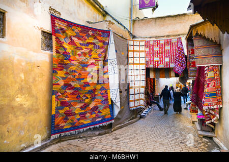 Eine schmale Straße in den Souks in der Medina mit marokkanischen Teppich Geschäfte, Fes, Marokko Stockfoto