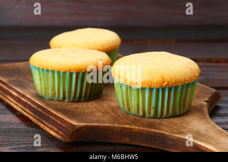 Fertig gebackene Muffins auf einem Holztisch Stockfoto