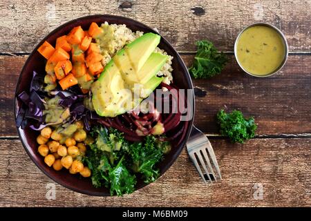 Buddha Schüssel mit Quinoa, Avocado, Kichererbsen, Gemüse auf einem Holz Hintergrund, gesunde Ernährung Konzept. Ansicht von oben. Stockfoto