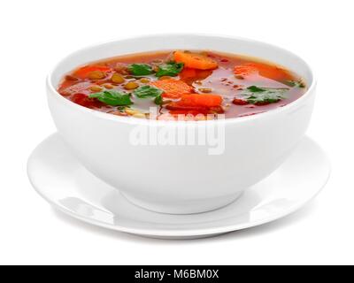 Hausgemachte Tomate, Linsensuppe in einer weißen Schüssel mit Untertasse. Seitliche Sicht auf einem weißen Hintergrund. Stockfoto