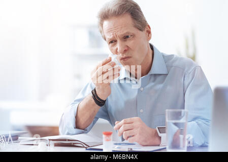 Freudlos nachdenklicher Mann mit einem Papiertuch Stockfoto