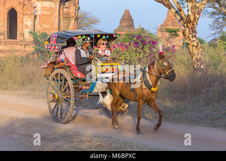 Touristen, die eine Fahrt mit Pferd und Wagen in der Abendsonne in Bagan, Myanmar (Birma), Asien im Februar Stockfoto