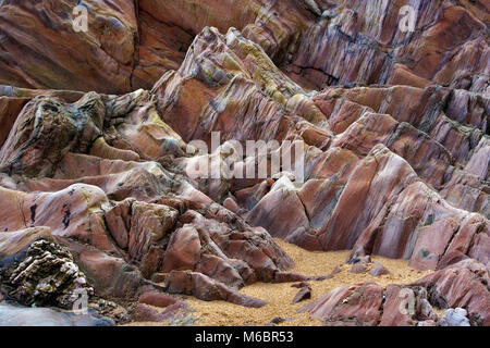 Ein Blick auf die Details und abwechslungsreiche Tonumfang eines Felsbrocken auf Bigbury-on-Sea Strand in Devon, Großbritannien. Stockfoto