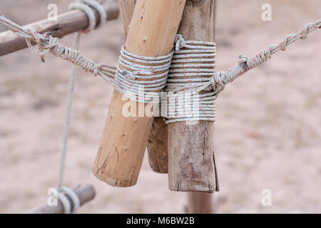 Ein Seil in einem Knoten um einen Zaun Pfosten gebunden ist, Seil gebunden Knoten Holz Pol Stockfoto