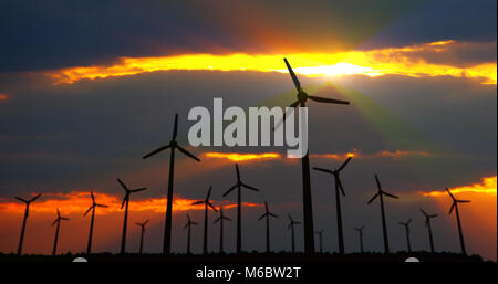 Windenergieanlagen Silhouette auf dramatische Himmel Hintergrund. Energie Windmühlen im Konzept der ökologischen Strom. Stockfoto