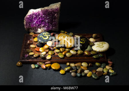 Amethyst Kristall und bunten Steine mit Om Symbol lackiert Stockfoto