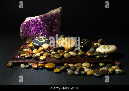 Amethyst Kristall und bunte Steine über ein Holzbrett Stockfoto