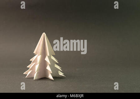 White Christmas Tree in Origami auf grauem Hintergrund Stockfoto