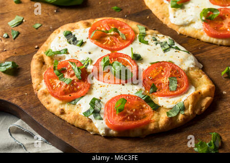 Mozarella, Basilikum und Tomaten Fladenbrot PIzza auf Naan Brot Stockfoto