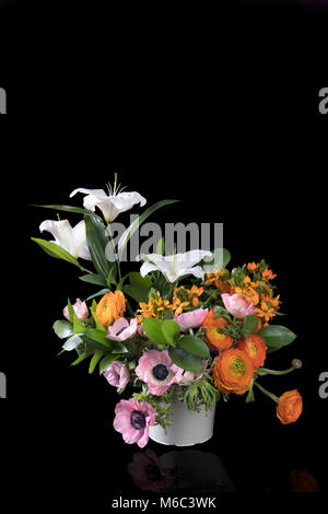 Eine Hochzeit Blumenstrauß aus Ranunkeln, Anemonen und Ruscus auf dem schwarzen Hintergrund Stockfoto