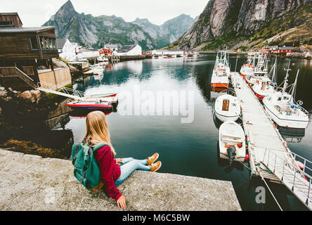 Junge Frau touristische Entspannen auf Brücke über den Fjord auf den Lofoten Inseln, Norwegen Reisen Wandern lifestyle Konzept Abenteuer outdoor Sommer Ferien Stockfoto