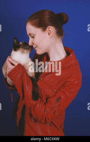 Junge Frau berühren Nasen mit cat Stockfoto