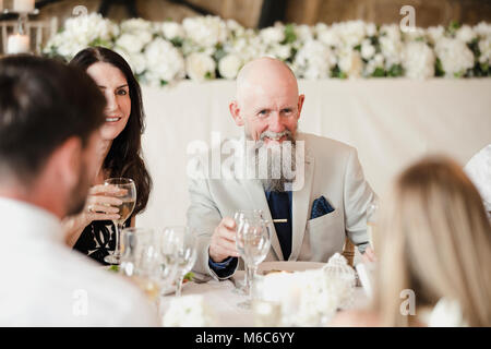 Eine Tabelle der glücklichen Hochzeit Gäste sind Geselligkeit, wie sie die Starter der ihre Mahlzeit essen. Stockfoto