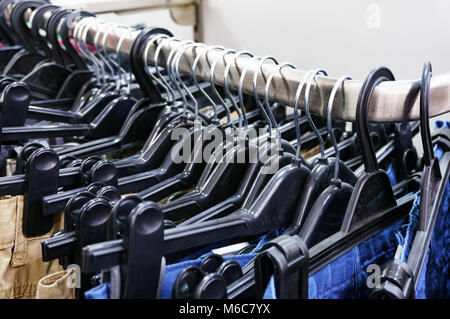 Nahaufnahme der Reihe der Hosen und Jeans auf dem Kleiderbügel im modernen Clothing Store Stockfoto