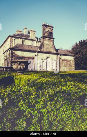 Fokus auf einem formgehölze Labyrinth mit ein schottisches Herrenhaus im Hintergrund Stockfoto