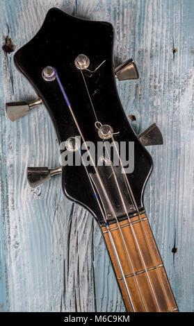 Spindelstock des Vintage Schwarz 4 String e-bass gitarre auf Holz- Hintergrund Stockfoto