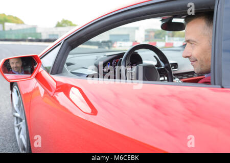 Mann in Sportwagen Gesicht in eingefasst wider Stockfoto