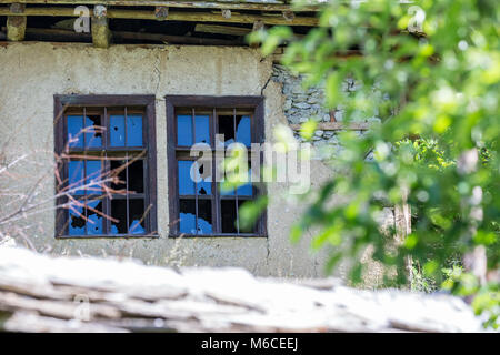 Zerbrochene Fenster auf dem erdwall der verlassenen Haus Stockfoto