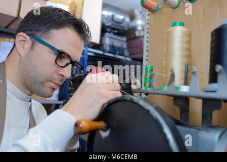 Junge Schuhmacher Arbeiten in der Werkstatt Stockfoto