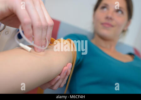 In der Nähe von Doktor injizierenden Patienten mit Spritze Blut zu sammeln Stockfoto