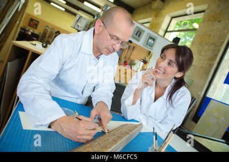 Handwerker arbeiten an der Dekoration eines Holz- Bilderrahmen Stockfoto