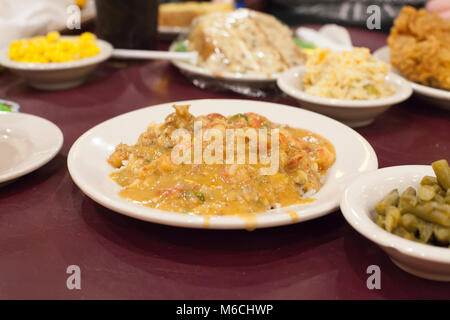 Eine Schüssel crawfish etouffee auf einem Tisch mit Lebensmitteln gefüllt Stockfoto