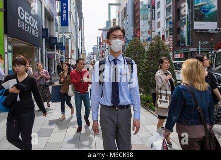 Der Mann trägt eine Coronavrius-Maske auf der Straße im Stadtteil Ginza in Tokio, Japan Stockfoto