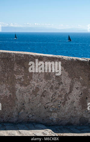 Korsika: die Mauer aus Stein und Segelboote Segeln in der Meerenge von Bonifacio, die Strecke des Meeres zwischen Korsika und Sardinien Stockfoto