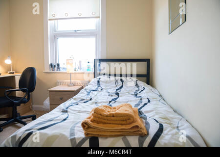 Studenten Zimmer in einem Studentenhaus lassen, während Sie bleiben mit dem Hausbesitzer sind, die das Bett und der Schreibtisch Bereiche Stockfoto