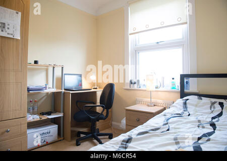 Studenten Zimmer in einem Studentenhaus lassen, während Sie bleiben mit dem Hausbesitzer sind, die das Bett und der Schreibtisch Bereiche Stockfoto