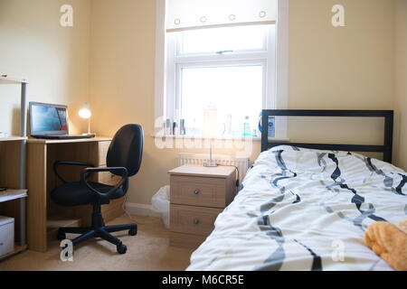 Studenten Zimmer in einem Studentenhaus lassen, während Sie bleiben mit dem Hausbesitzer sind, die das Bett und der Schreibtisch Bereiche Stockfoto