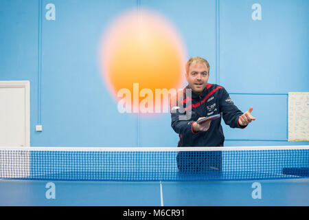 Ein Tischtennis Trainer bei Brighton und Hove Tischtennis club, schlägt die Kugel in der Nähe der Kamera. Stockfoto