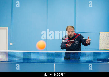 Ein Tischtennis Trainer bei Brighton und Hove Tischtennis club, schlägt die Kugel in der Nähe der Kamera. Stockfoto